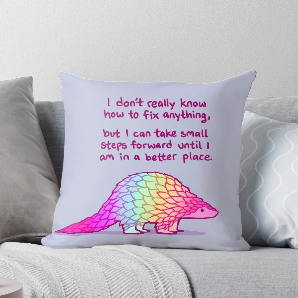 A soft, rainbow-colored pangolin pillow with a message of self-love and mental health affirmations.