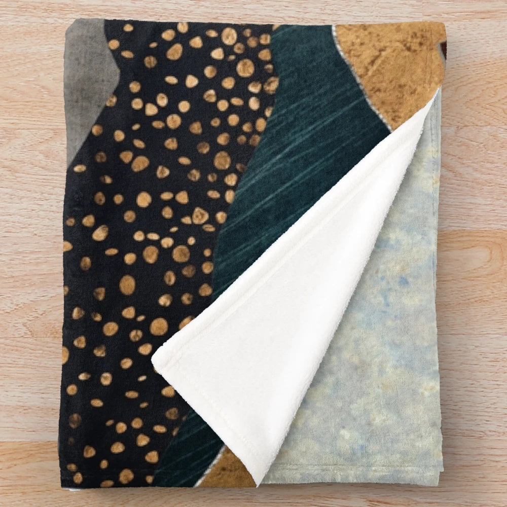 Soft and cozy amber plush blanket with a landscape design depicting a dusk sky over hills and mountains