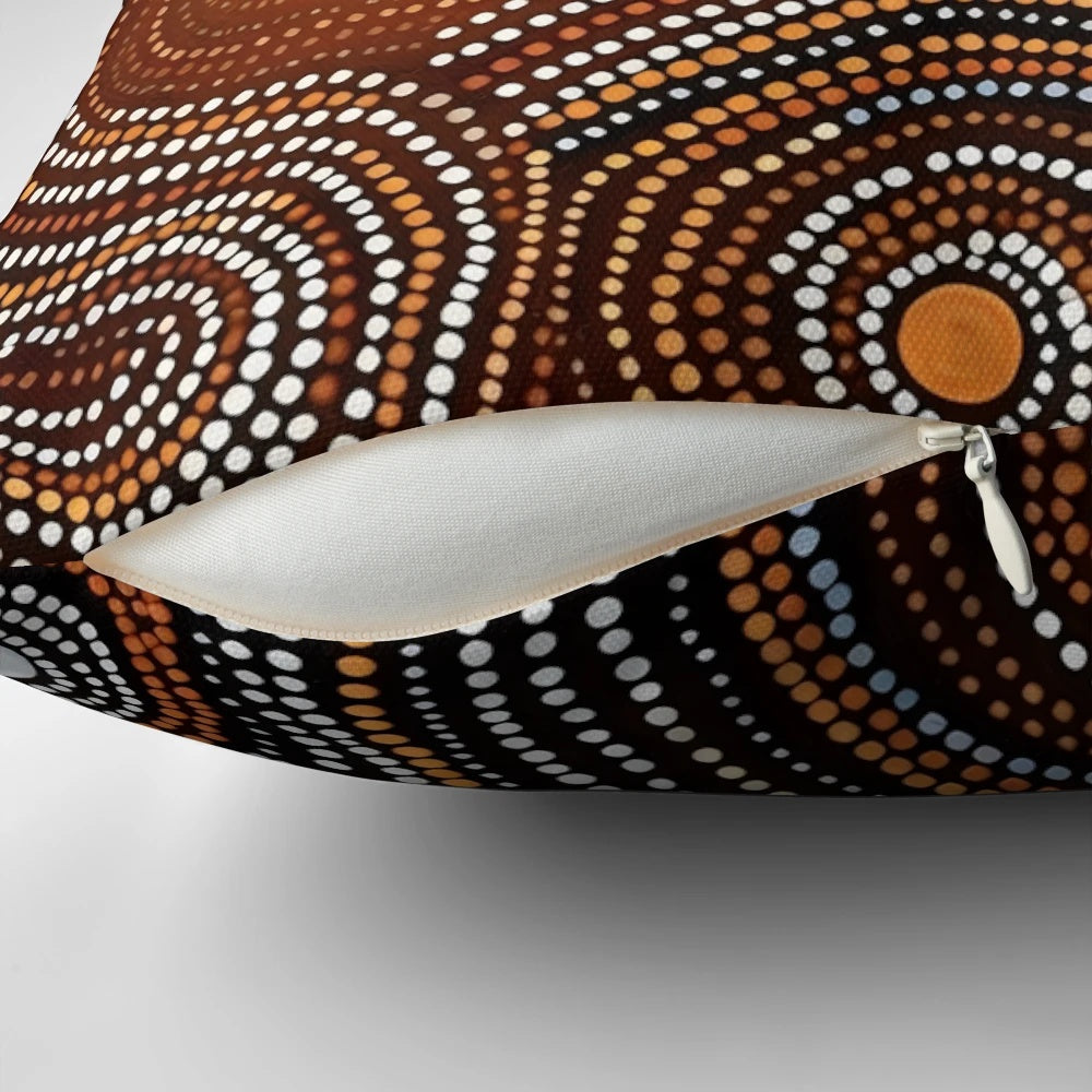Pillow featuring contemporary Aboriginal art with dots, curved lines, and earthy colors that conveys stories and spirituality.