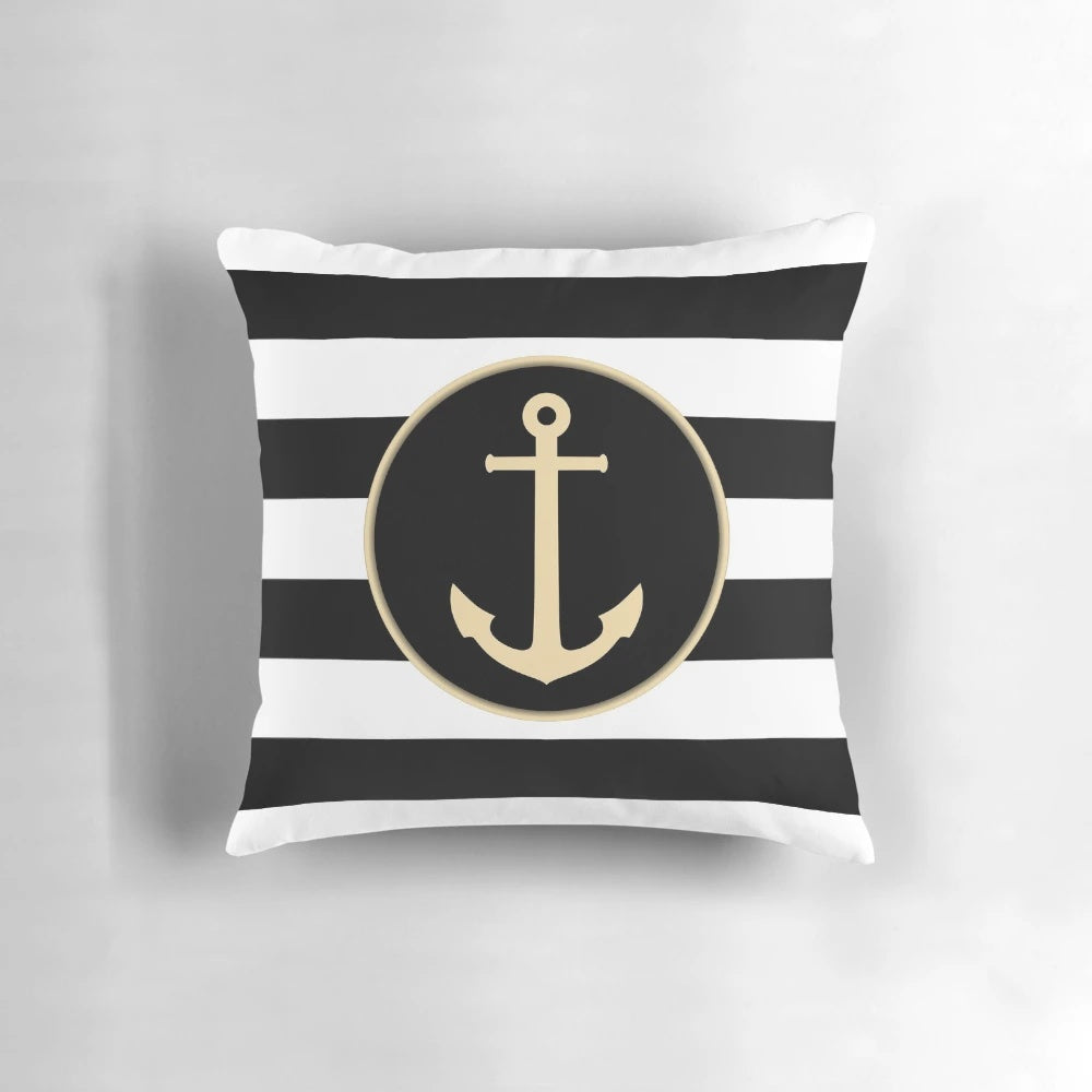 Black and white striped pillow with a gold anchor design, perfect for coastal or modern home decor.
