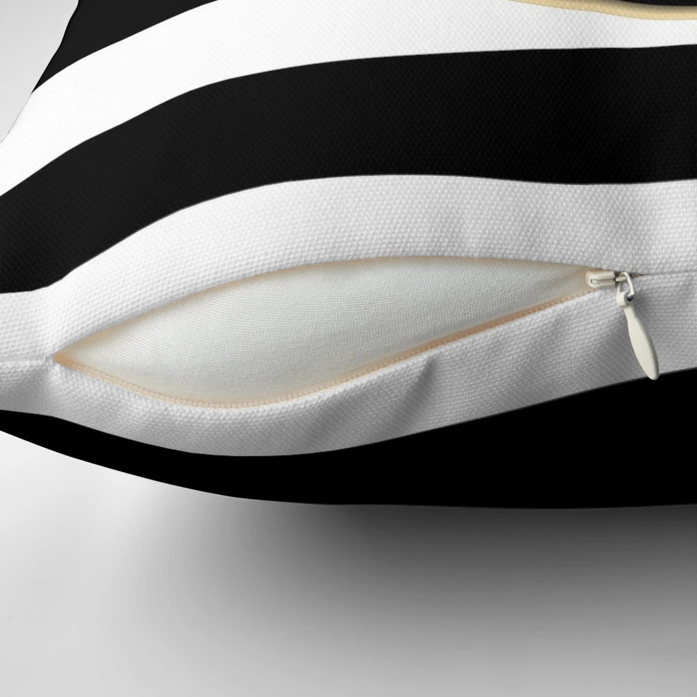 Black and white striped pillow with a gold anchor design, perfect for coastal or modern home decor.