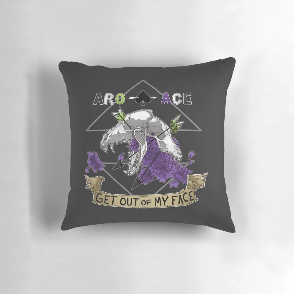 Aromantic and asexual pride pillow with a sassy "Get Out of My Face" design featuring skulls, bones, and flowers.