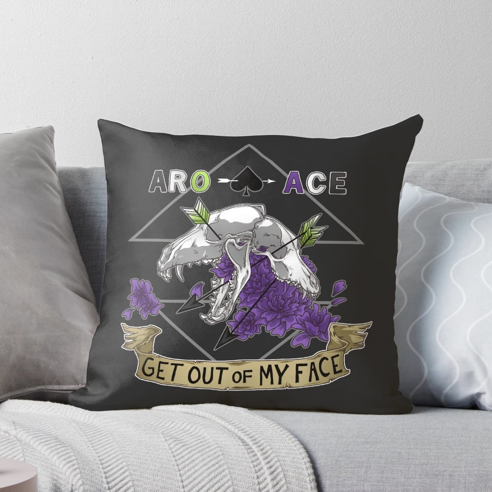 Aromantic and asexual pride pillow with a sassy "Get Out of My Face" design featuring skulls, bones, and flowers.