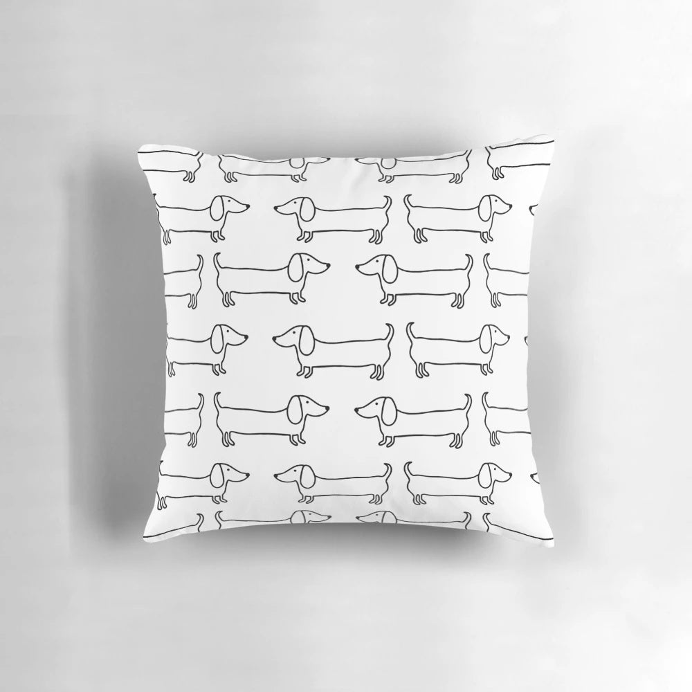 Black and white hand-drawn dachshund illustration on a decorative pillow