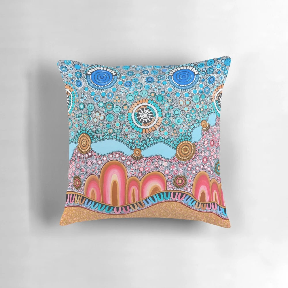 Pillow featuring indigenous-style dot painting design with ocean and landscape elements