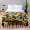 Abstract grey and mustard yellow paint brush effect on a navy blue plush blanket