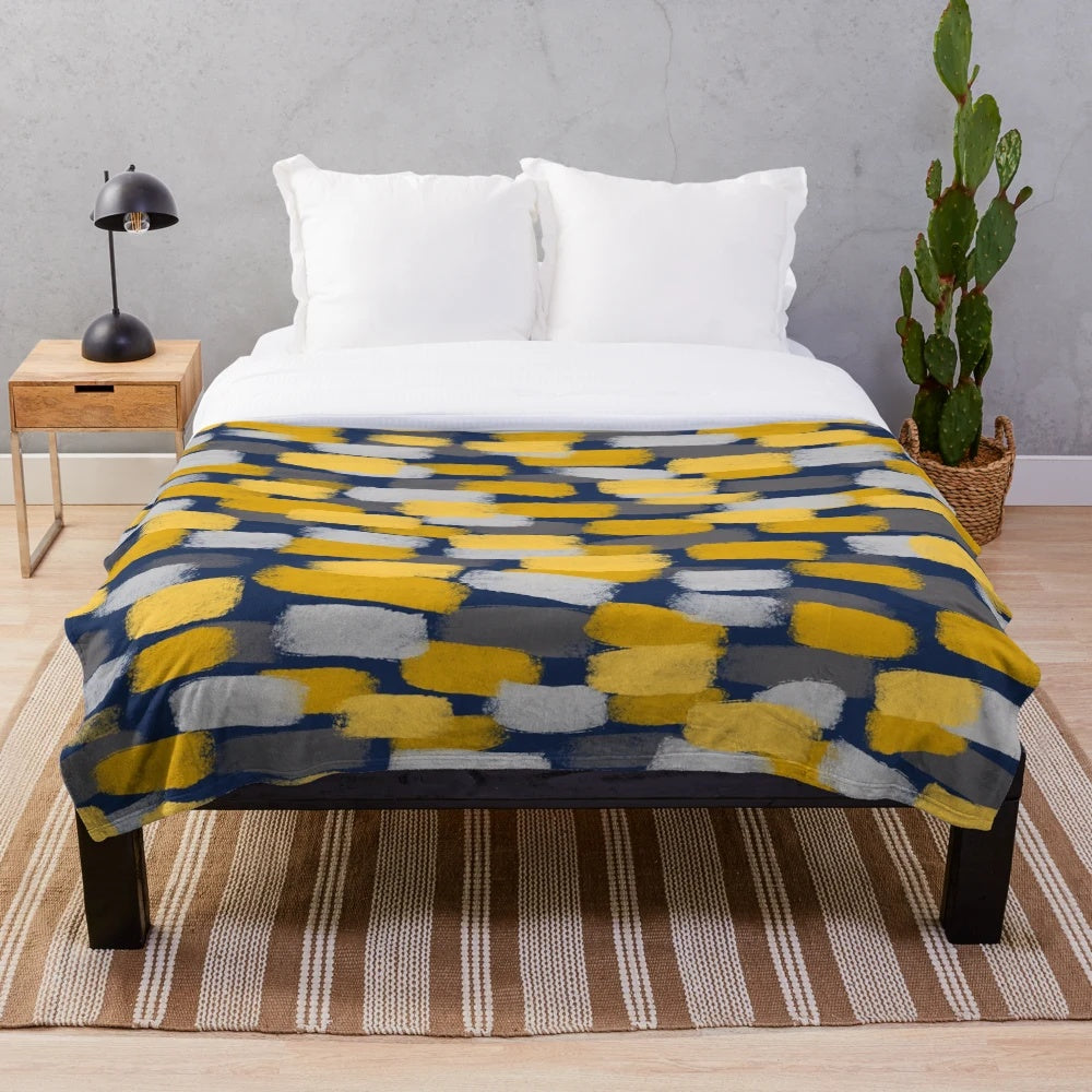 Abstract grey and mustard yellow paint brush effect on a navy blue plush blanket