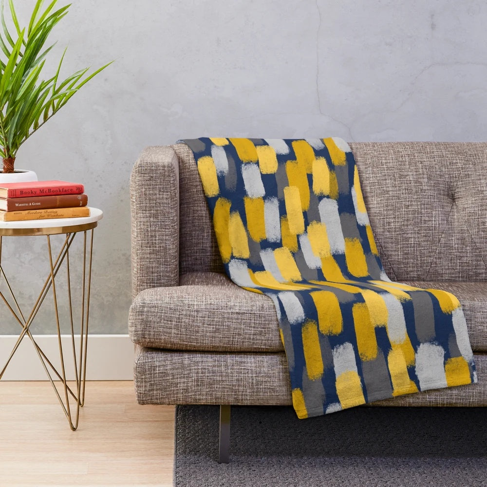 Abstract grey and mustard yellow paint brush effect on a navy blue plush blanket