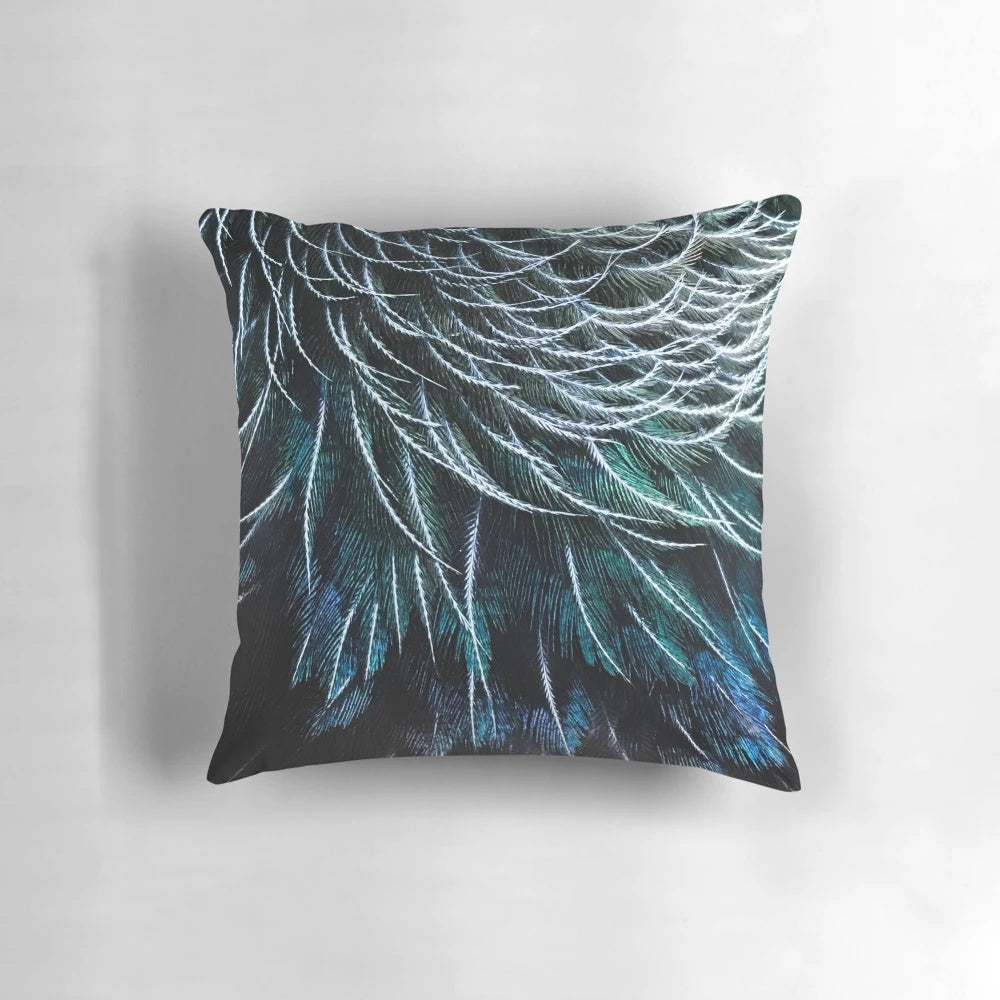 Close-up image of a vibrant tui feather, part of a handcrafted decorative pillow