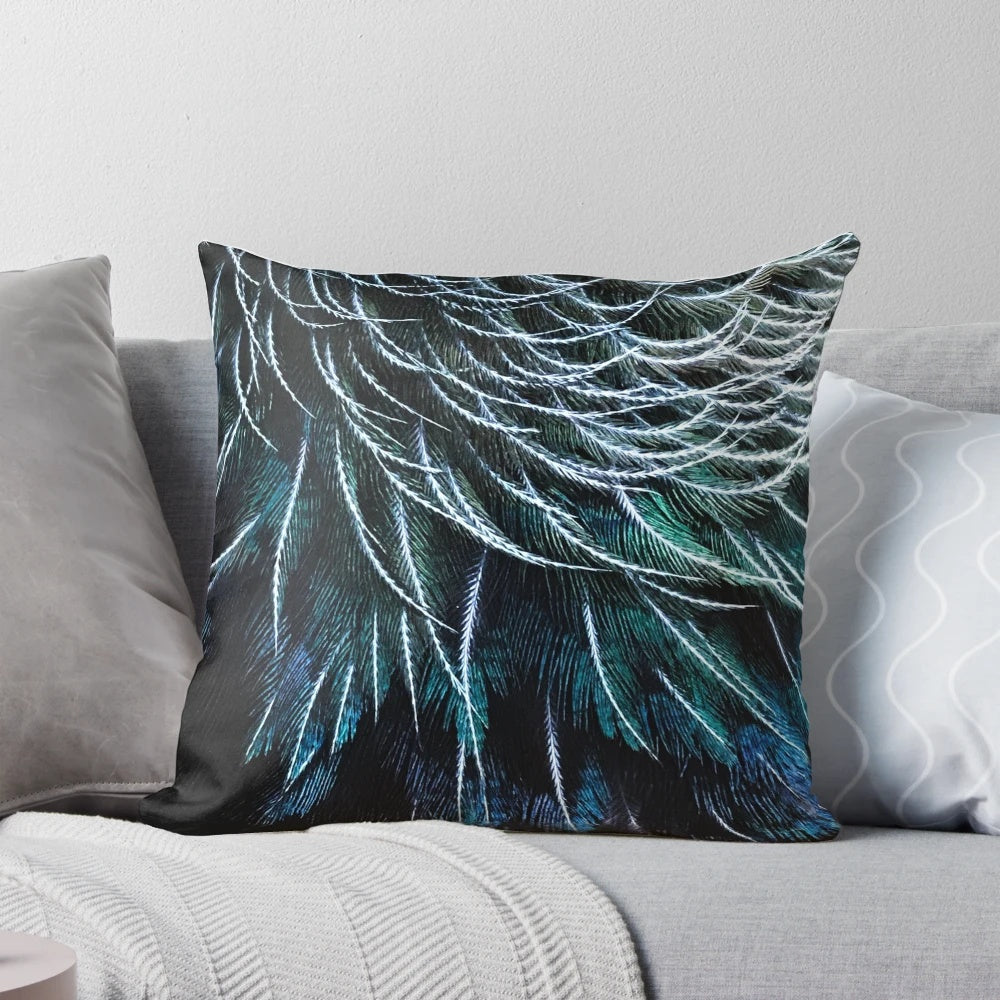 Close-up image of a vibrant tui feather, part of a handcrafted decorative pillow