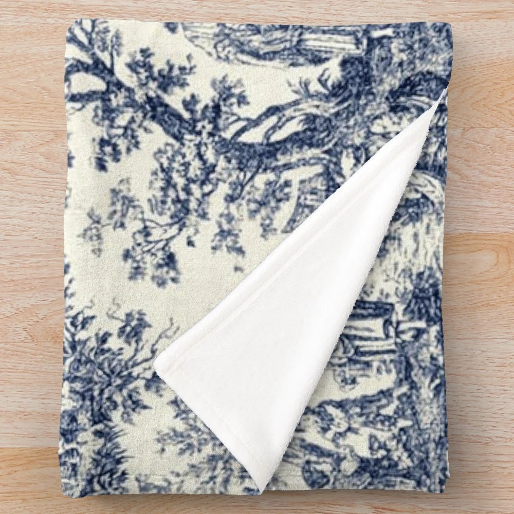 Soft, cozy plush blanket featuring a classic toile de jouy pattern in navy and white