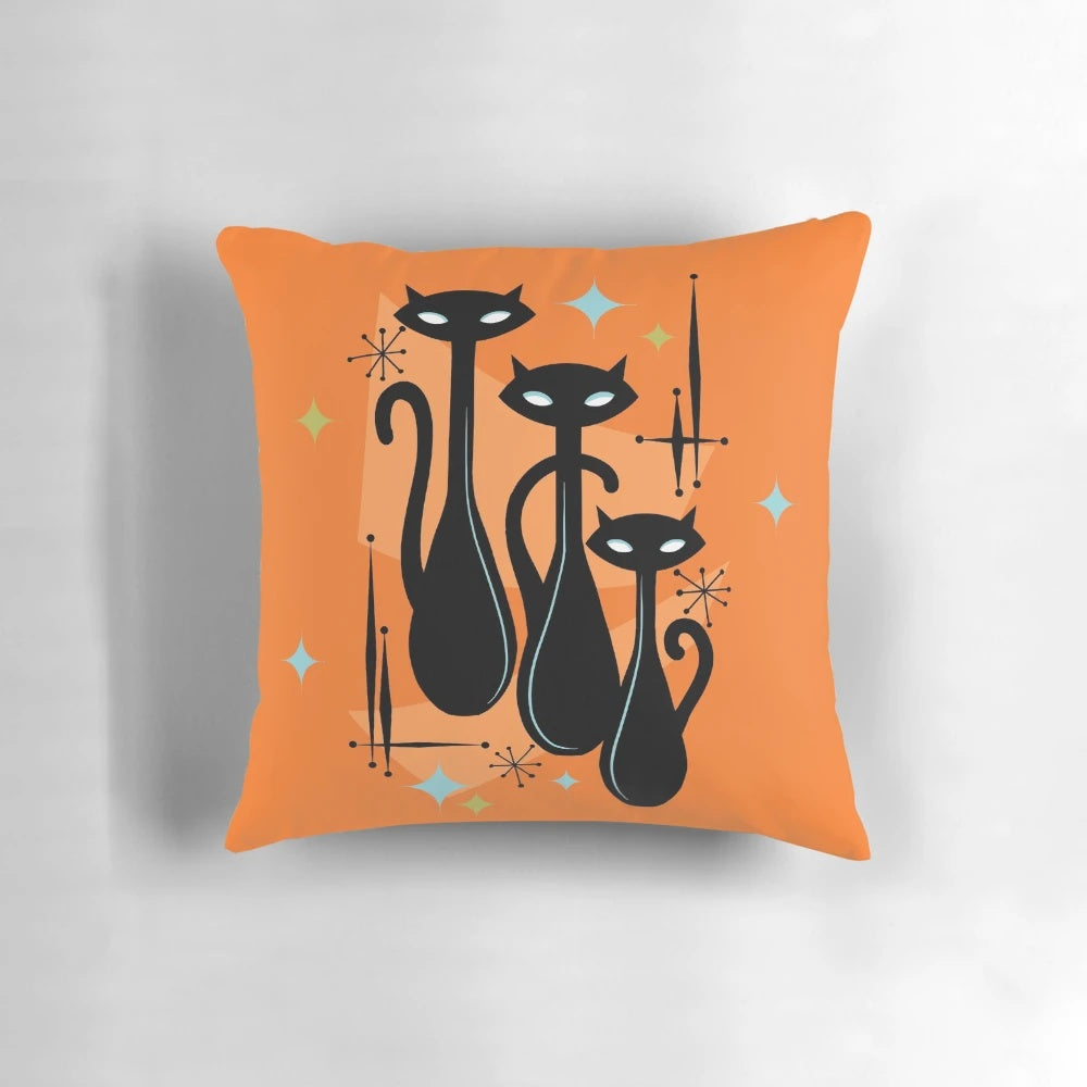 Vibrant orange, black, and white cat trio pillow in a retro, atomic age style design