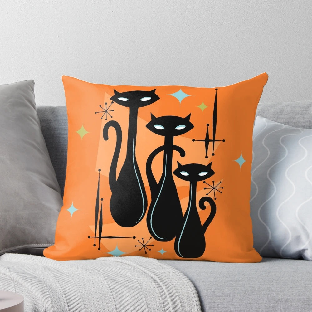 Vibrant orange, black, and white cat trio pillow in a retro, atomic age style design