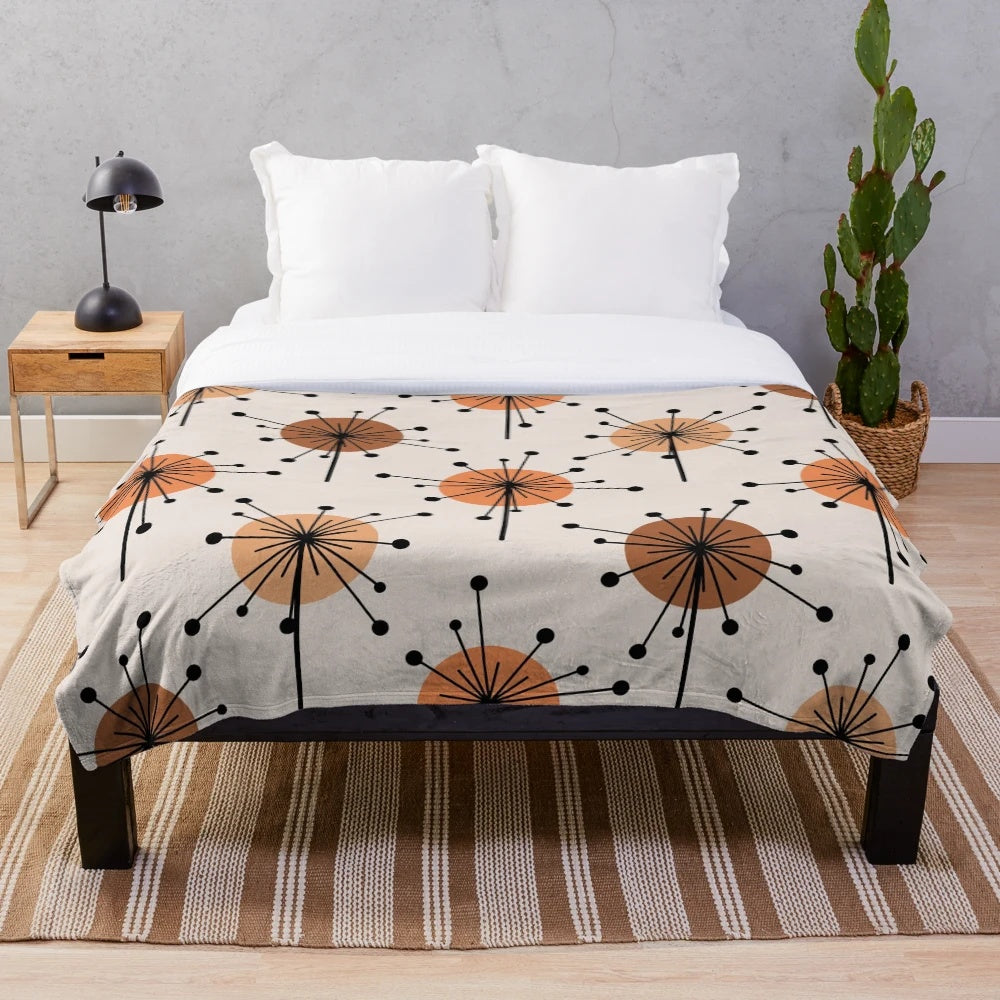Atomic era inspired plush blanket with vibrant orange and tan sputnik starburst floral pattern