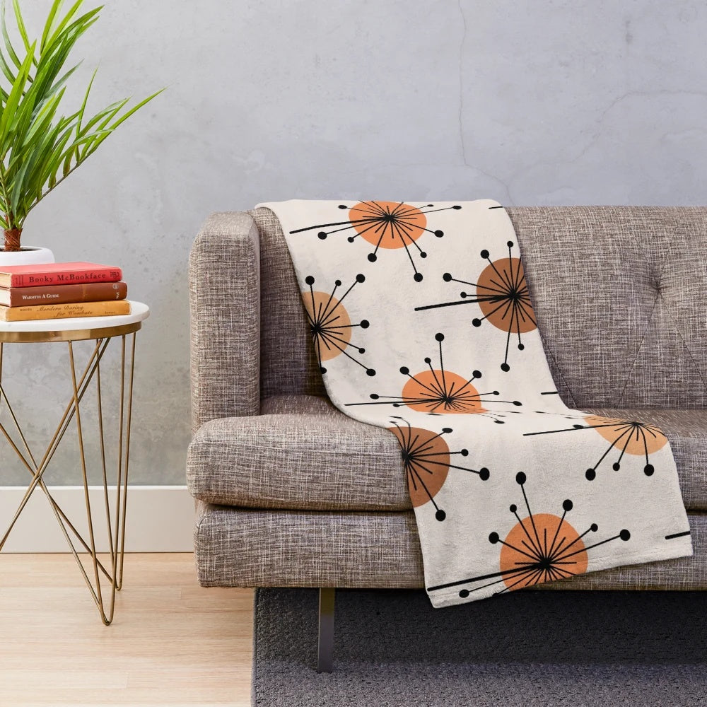 Atomic era inspired plush blanket with vibrant orange and tan sputnik starburst floral pattern