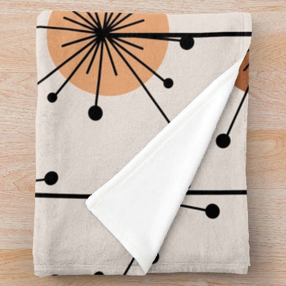 Atomic era inspired plush blanket with vibrant orange and tan sputnik starburst floral pattern