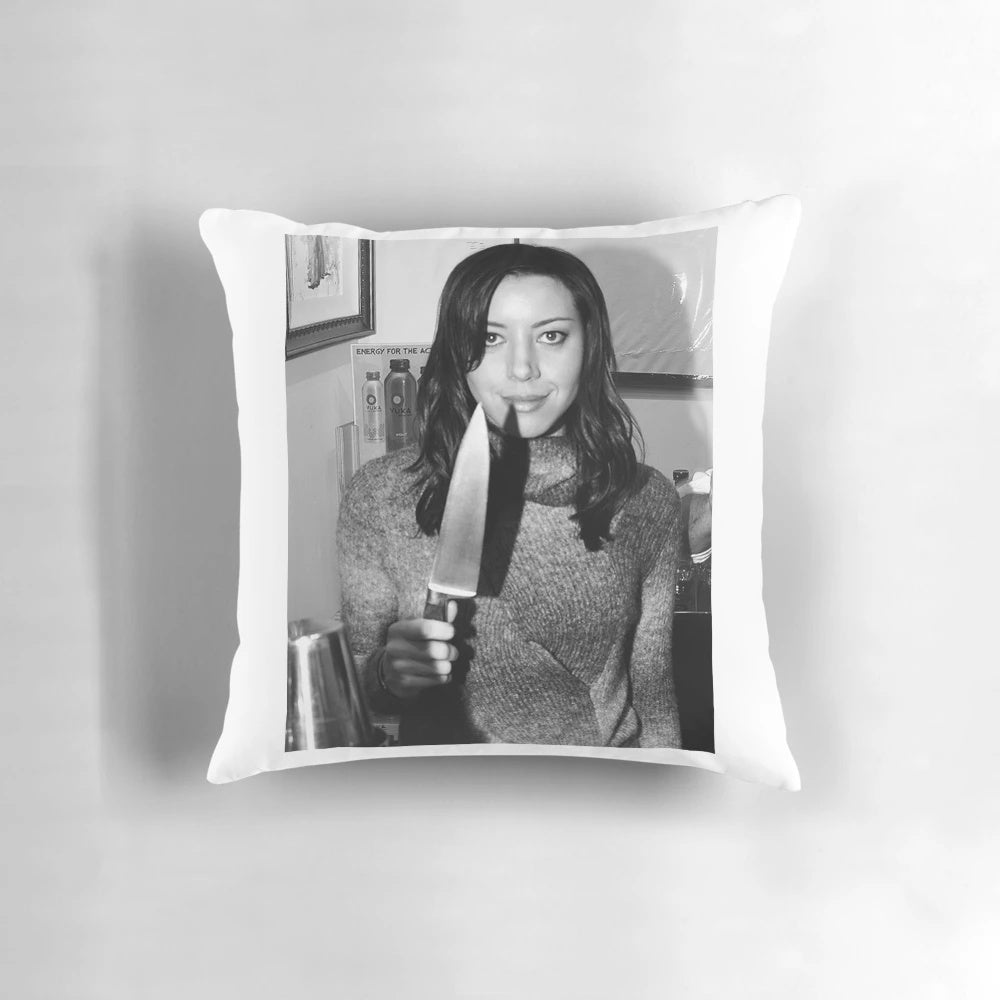 Aubrey Plaza from the TV show Parks and Recreation holding a knife, printed on a decorative pillow.