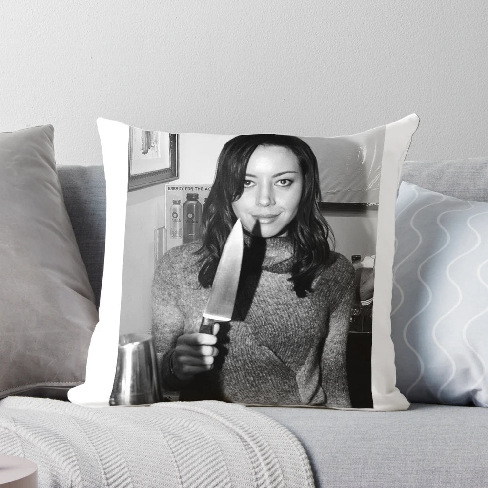 Aubrey Plaza from the TV show Parks and Recreation holding a knife, printed on a decorative pillow.
