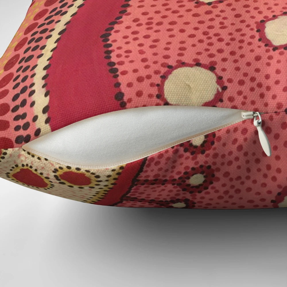 Colorful aboriginal dot art design on a pink and white pillow