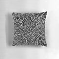 Patterned black and white pillow featuring aboriginal-inspired dot art and symbols
