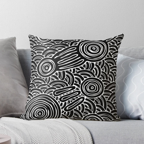 Patterned black and white pillow featuring aboriginal-inspired dot art and symbols