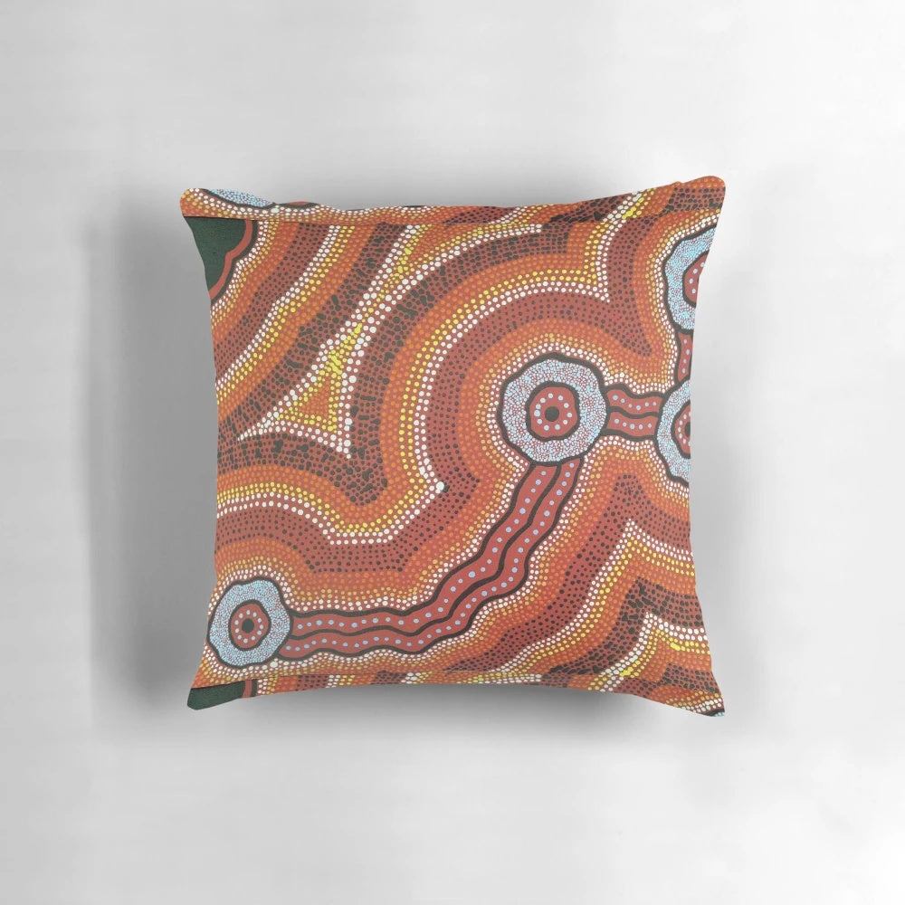 Vibrant acrylic painting of an Australian aboriginal waterhole scene on a decorative throw pillow