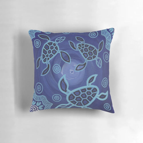 Decorative throw pillow featuring an authentic aboriginal art design of sea turtles in blue, black, and ochre colors.
