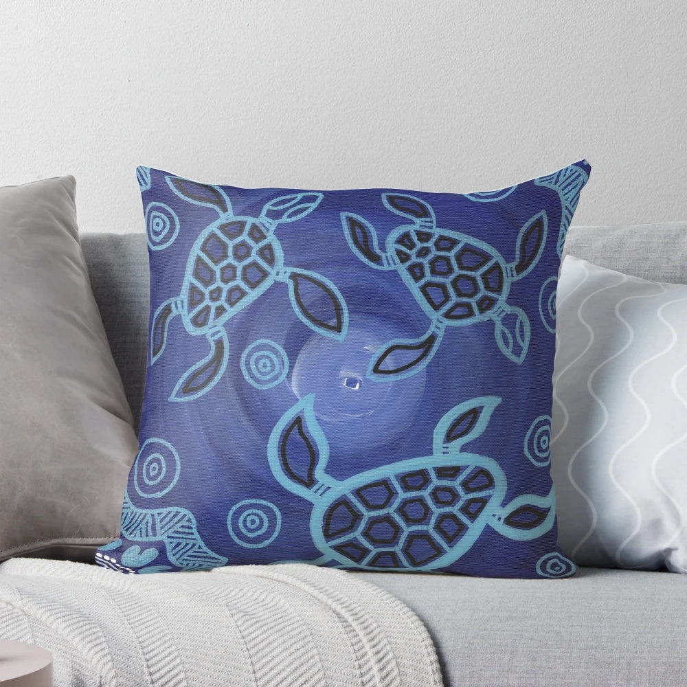 Decorative throw pillow featuring an authentic aboriginal art design of sea turtles in blue, black, and ochre colors.