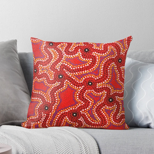 Vibrant aboriginal dot painting artwork on a comfortable throw pillow