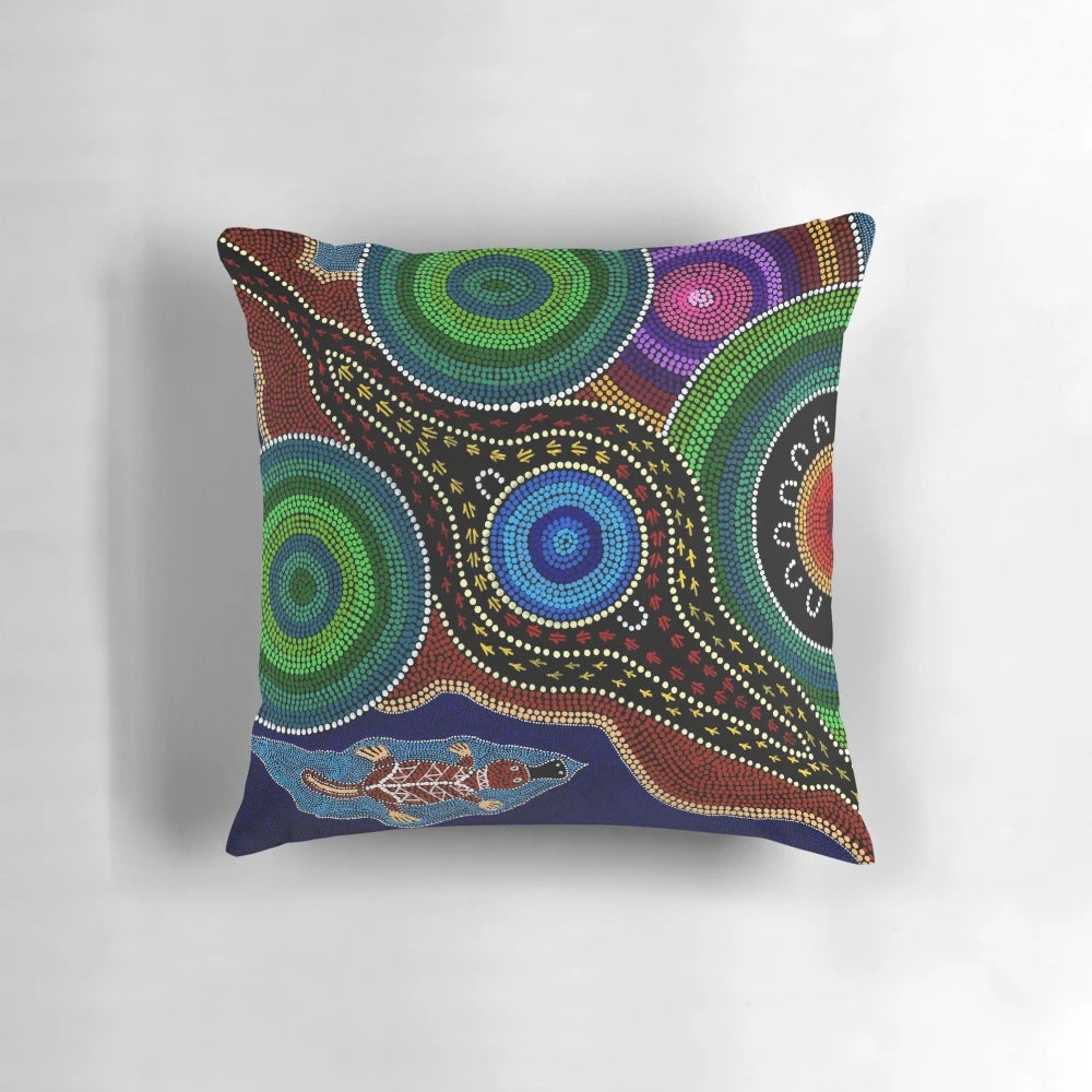 Colorful Australian aboriginal dot painting style design featuring a playful platypus on a soft, comfortable pillow.