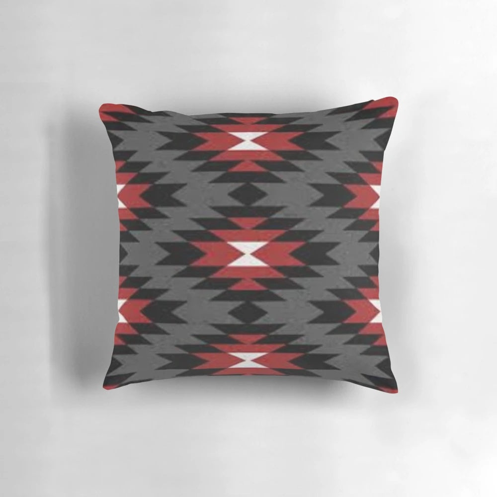 A decorative throw pillow featuring a vibrant and authentic native american tribal design in black, white, red, and grey colors.