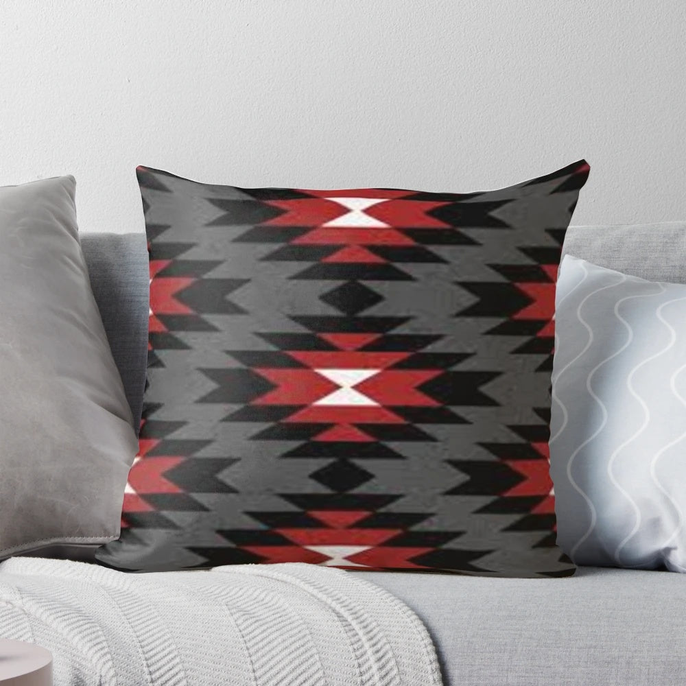 A decorative throw pillow featuring a vibrant and authentic native american tribal design in black, white, red, and grey colors.