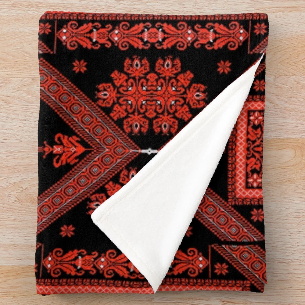 Palestinian embroidered plush blanket featuring traditional red and black designs