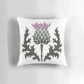 A vibrant purple Scottish thistle flower, the national flower of Scotland, against a background of the Scottish highlands.