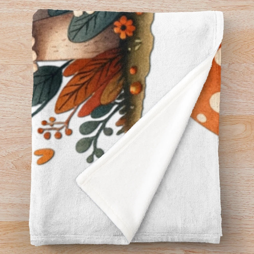 Whimsical illustration of autumn mushrooms and pumpkins on a cozy plush blanket