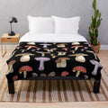 Plush blanket featuring a hand-painted design of autumnal mushrooms and pastel-colored foliage