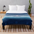 Aztec-inspired plush blanket with blue and orange patterns featuring the Aztec sun stone