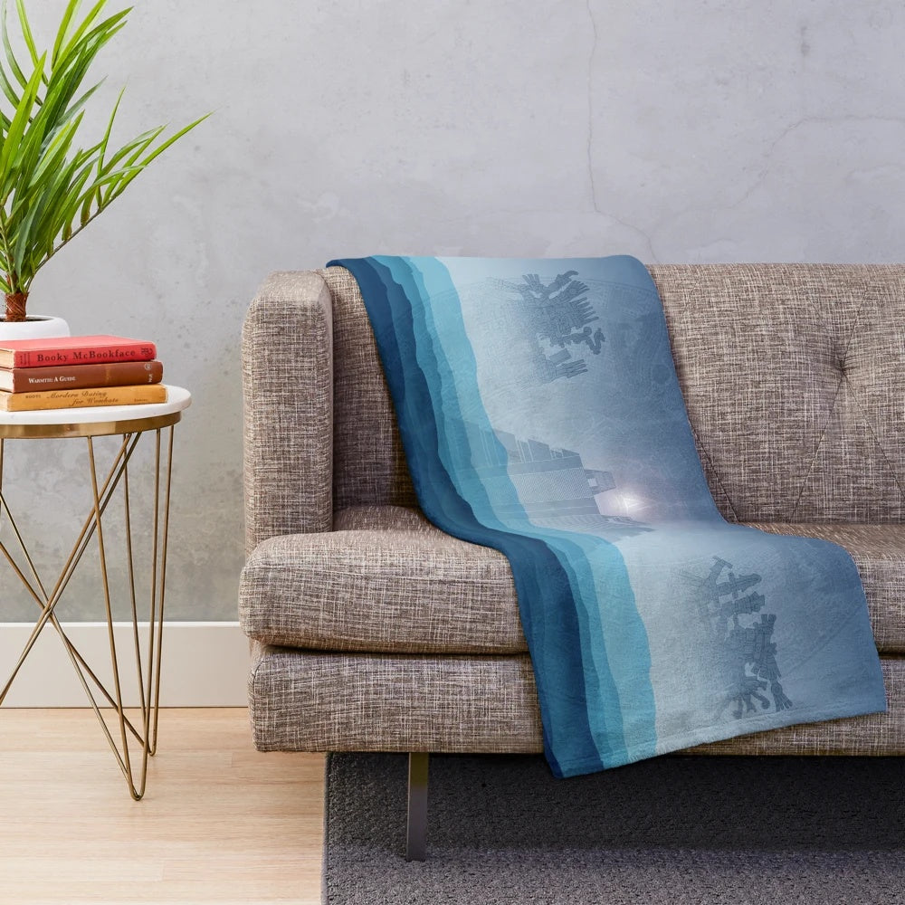 Aztec-inspired plush blanket with blue and orange patterns featuring the Aztec sun stone