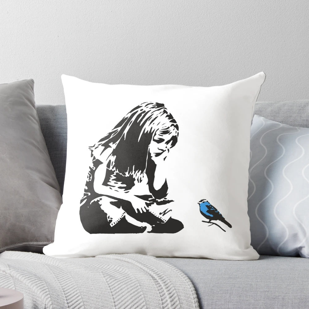 Pillow featuring a Banksy graffiti artwork of a girl with a blue bird