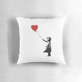 Banksy stencil artwork of a girl with a red heart-shaped balloon in windy weather, depicted on a pillow.