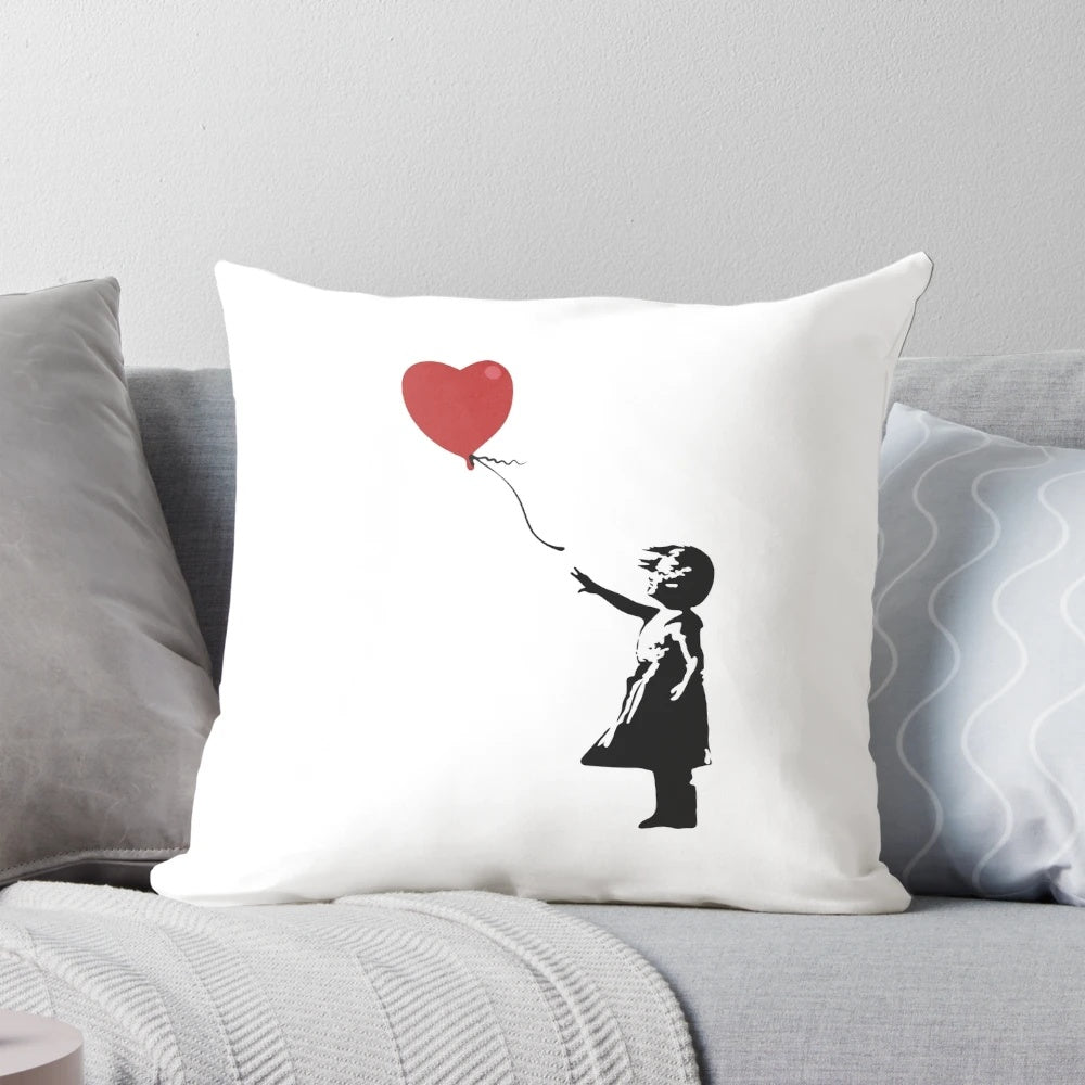 Banksy stencil artwork of a girl with a red heart-shaped balloon in windy weather, depicted on a pillow.