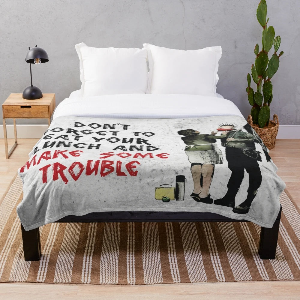 Banksy-inspired plush blanket with anti-capitalist graffiti-style art