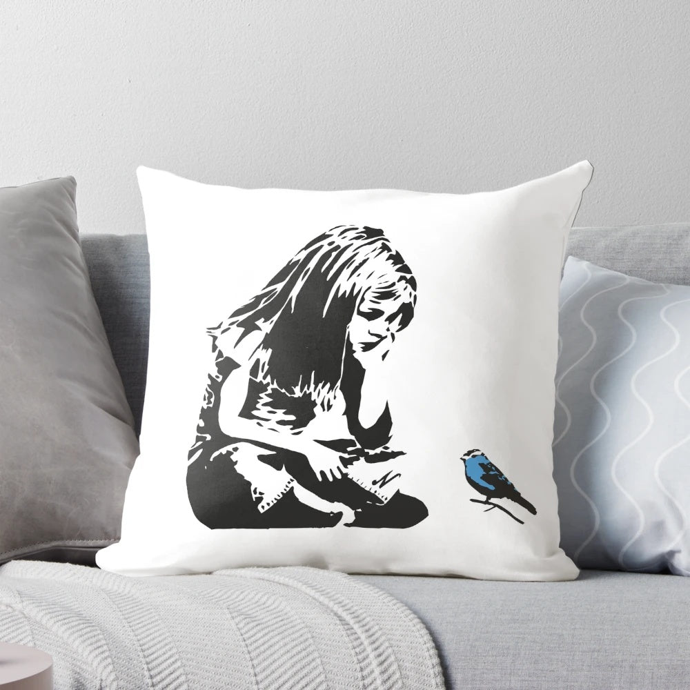 Pillow featuring a Banksy-style stencil graffiti of a girl with a blue bird, captured in Hull city centre, England.