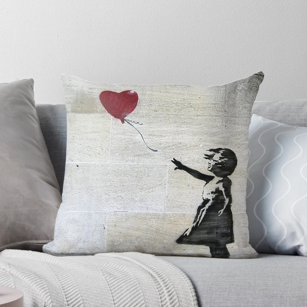 Artistic throw pillow featuring Banksy's iconic Girl with a Red Balloon stencil design