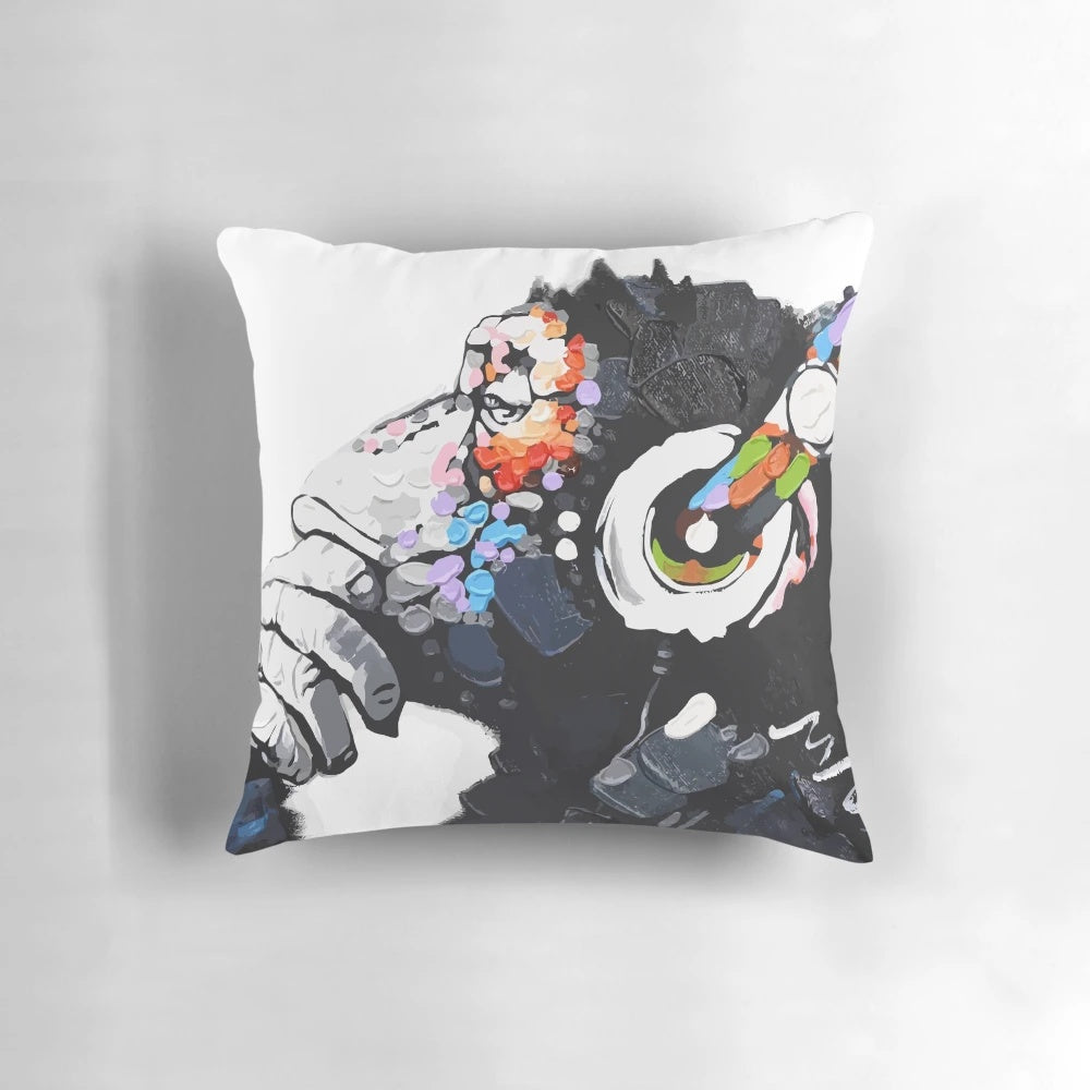 An image of a Banksy-inspired white pillow featuring a monkey wearing headphones and appearing to be deep in thought.