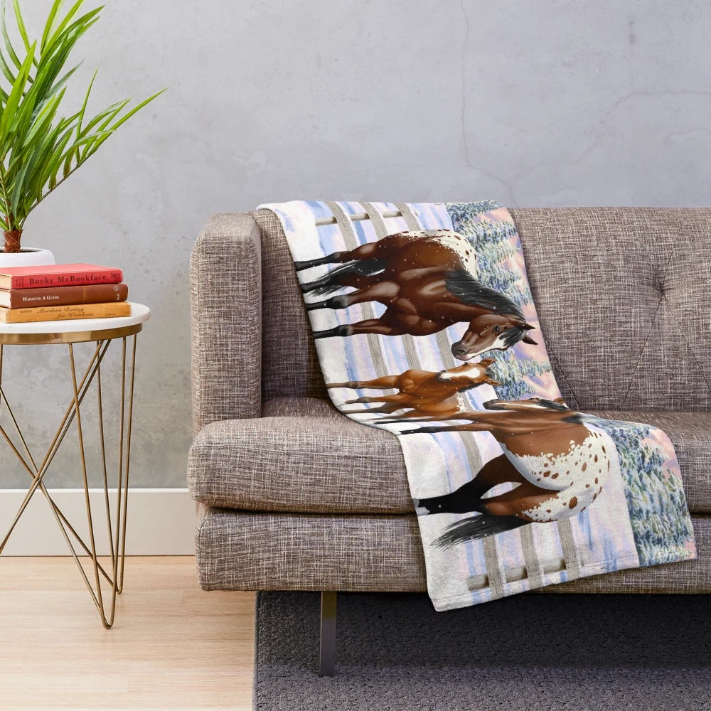 Appaloosa horses in a snowy winter scene on a plush blanket