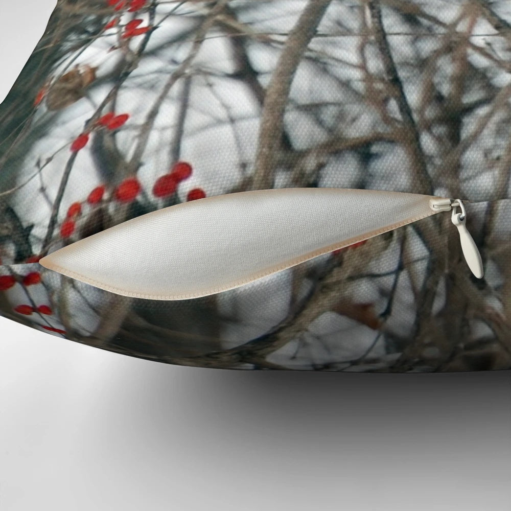 Vibrant red cardinal perched on a snowy branch, decorative holiday pillow
