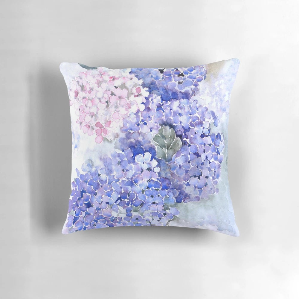 Vibrant blue hydrangea flowers in a watercolor design on a decorative pillow.