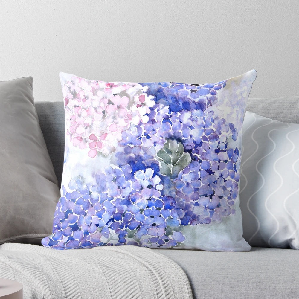 Vibrant blue hydrangea flowers in a watercolor design on a decorative pillow.
