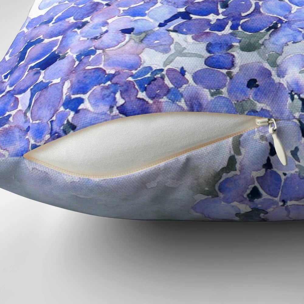 Vibrant blue hydrangea flowers in a watercolor design on a decorative pillow.